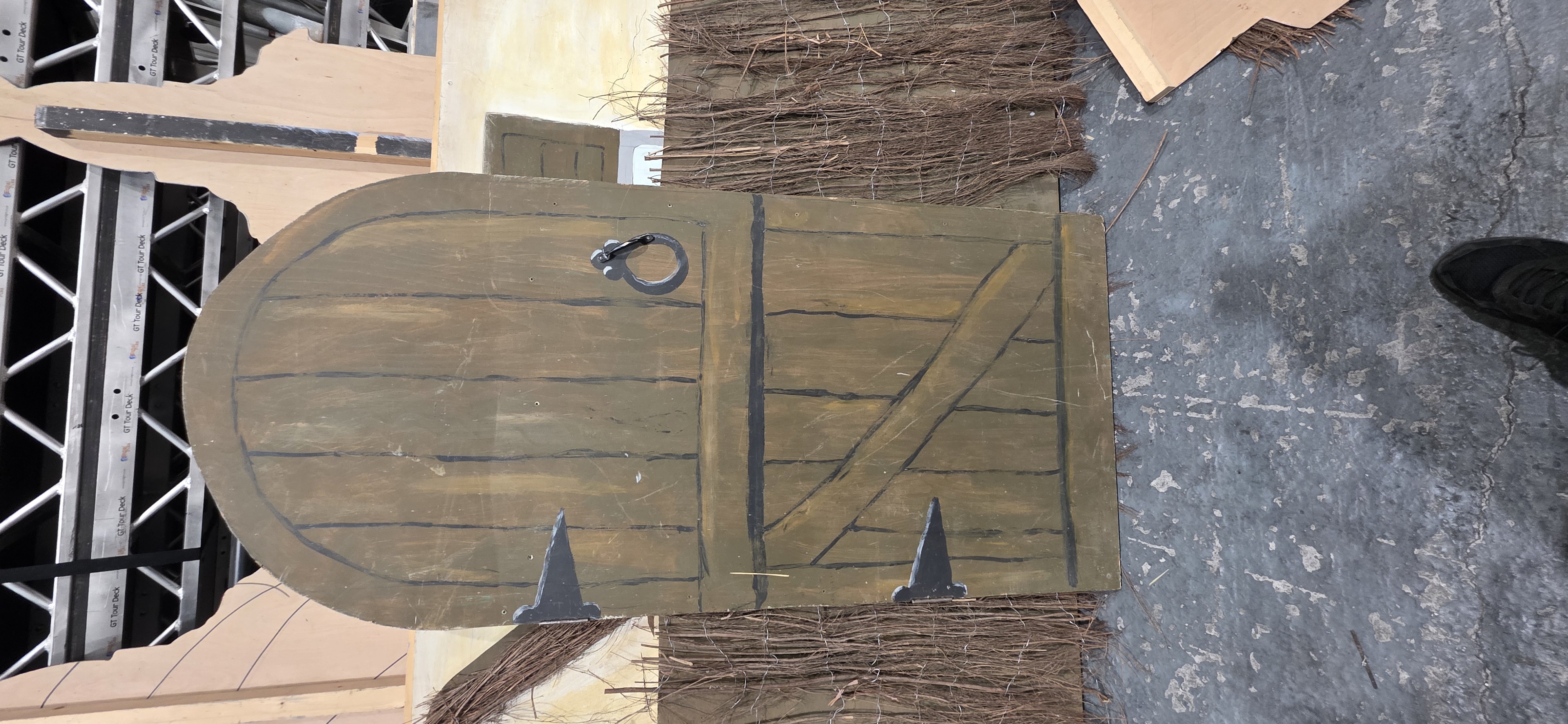 Themed scenic prop — painted arched door with thatched-style trim, fairy-tale styling