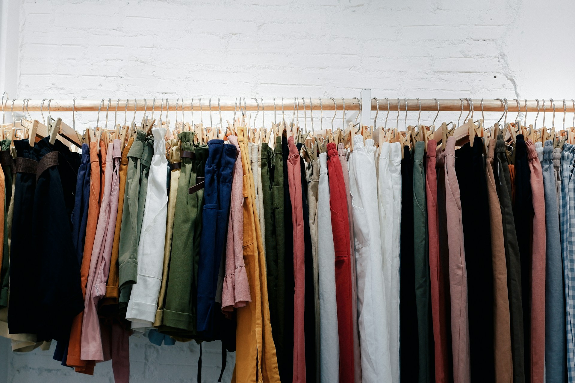 Colourful theatrical costumes hanging on a wooden wardrobe rack — Sugar Plum Costumes hire range